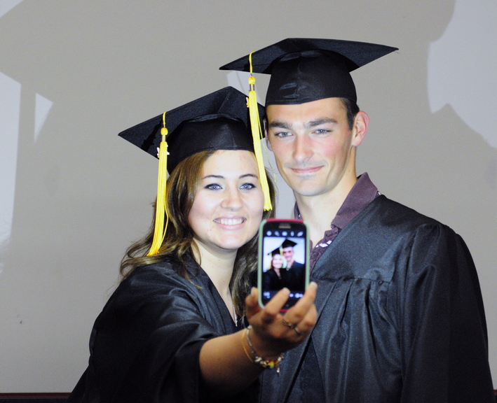 GOAL ACHIEVED: Sonja Hall, left takes a photo with one of her physical therapy assistant classmates, Austin Merrill, before their Kennebec Valley Community College graduation on Saturday at the Augusta Civic Center.