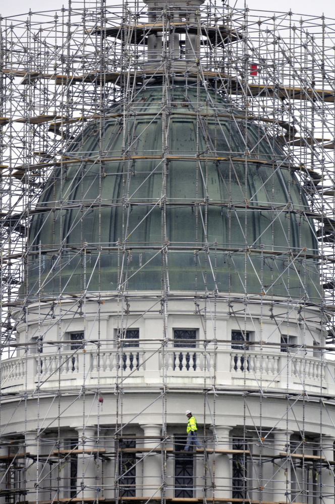 NEW DOME: A construction worker walks on the staging surrounding the State House dome in Augusta on Monday. Legislative leaders are discussing what to do with the old copper sheathing that will be removed starting in mid-June.