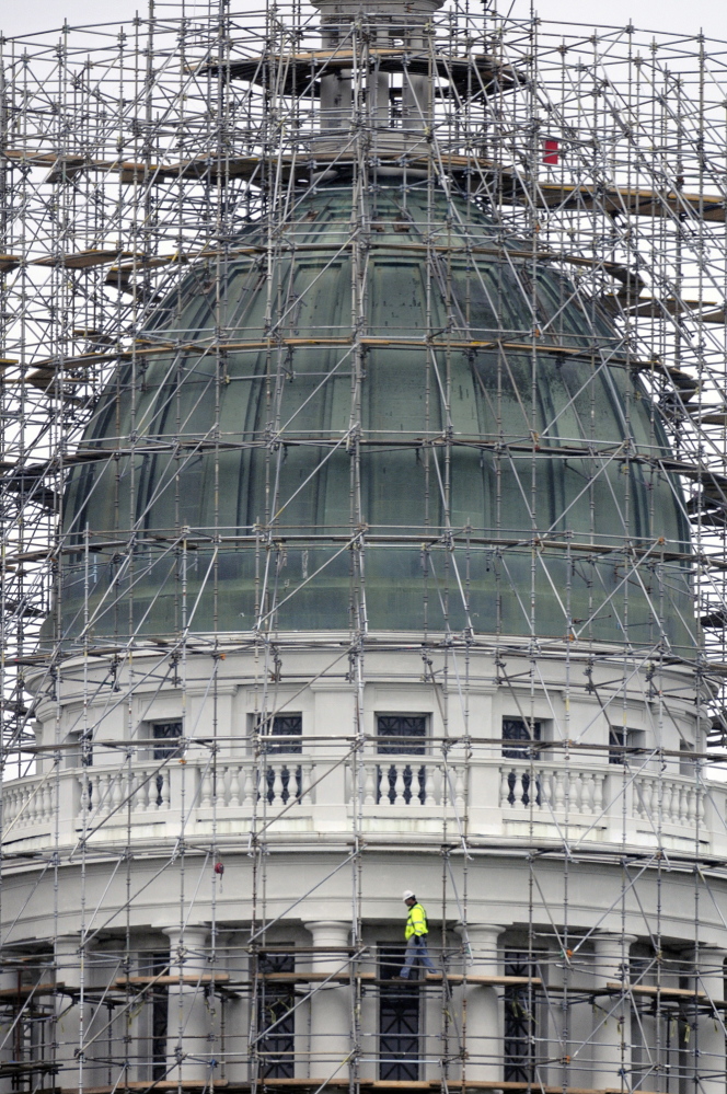 NEW DOME: A construction worker walks on the staging surrounding the State House dome in Augusta on Monday. Legislative leaders are discussing what to do with the old copper sheathing that will be removed starting in mid-June.