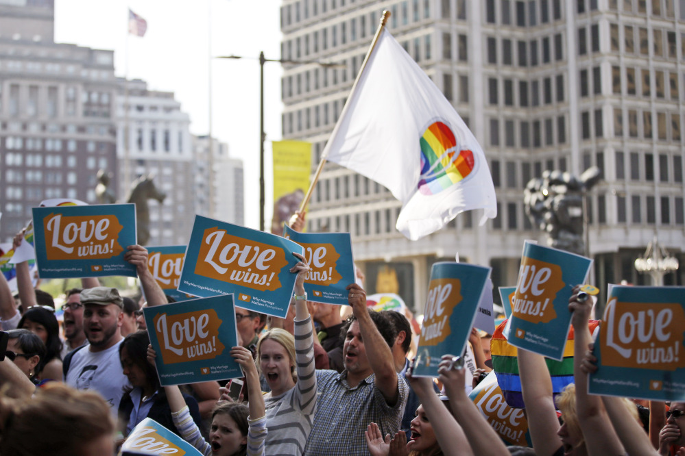 People hold up signs and cheer during a rally at City Hall, Tuesday, May 20, 2014, in Philadelphia. Pennsylvania’s ban on gay marriage was overturned by a federal judge Tuesday.