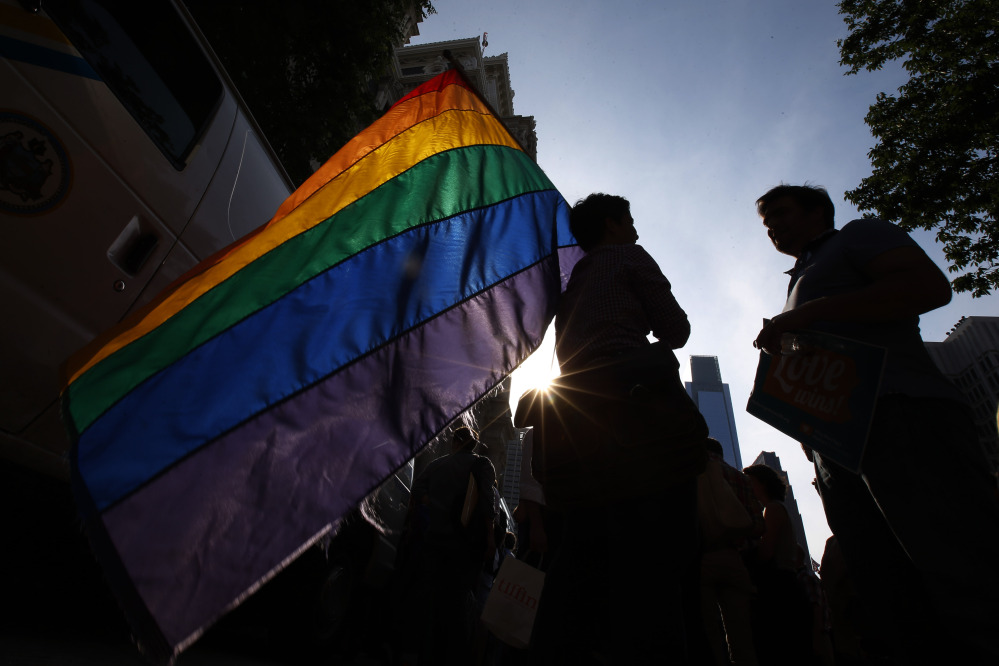 A person holds a flag during a rally at City Hall, Tuesday, May 20, 2014, in Philadelphia. Pennsylvania’s ban on gay marriage was overturned by a federal judge Tuesday.