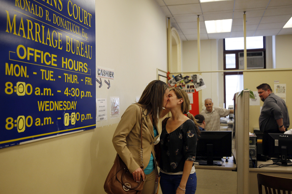 Ashley Wilson, left, and Lindsay Vandermay, right, both 29, kiss after getting their marriage license at the Philadelphia Marriage Bureau in City Hall, Tuesday, May 20, 2014, in Philadelphia. Pennsylvania’s ban on gay marriage was overturned by a federal judge Tuesday.