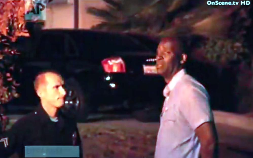 In this image taken from video from OnScene.tv, actor Michael Jace, right, is detained by police outside his home in Los Angeles on Monday night.