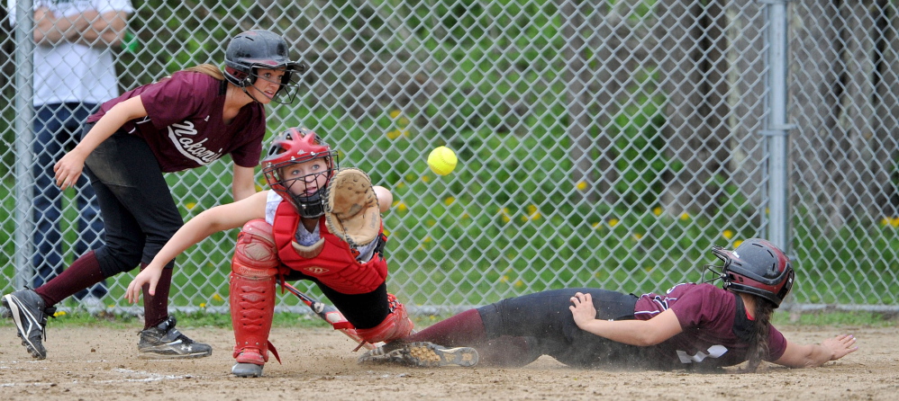 SAFE: Nokomis High School’s Sierra Fortin (1) slides safely across home plate ahead of the ball in front of Winslow High School catcher Kiana Richards on Wednesday in Newport. The Warriors won 7-2, improving their record to 12-0.