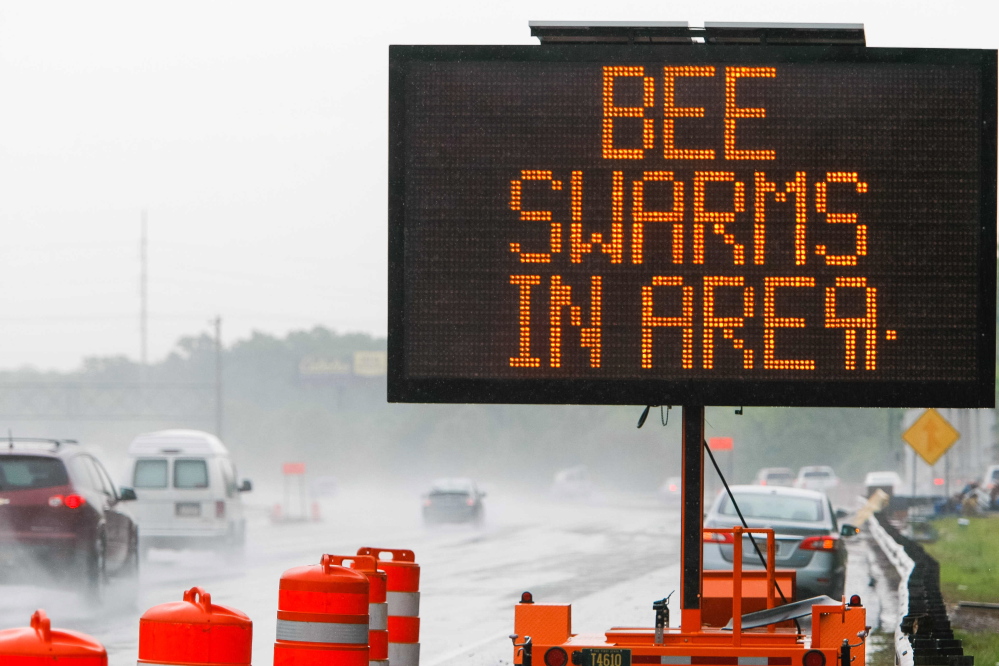 Traffic on Interstate 95 is met with a warning sign after a tractor-trailer spilled a load of 16 million to 20 million honeybees when it rolled over Tuesday near Newark, Del.