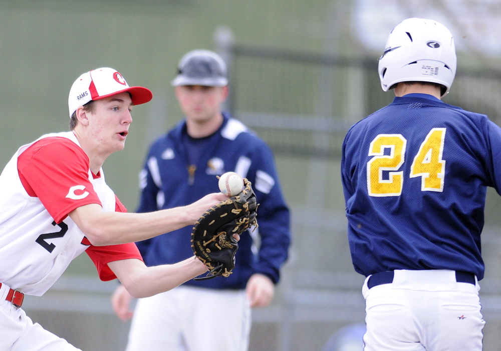 Staff photo by Andy Molloy Cony High School's Mitchell Bonenfant can't hold onto a throw Wednesday while attempting to tag Mt. Blue's Amos Herrin at first base during a baseball match up in Augusta.