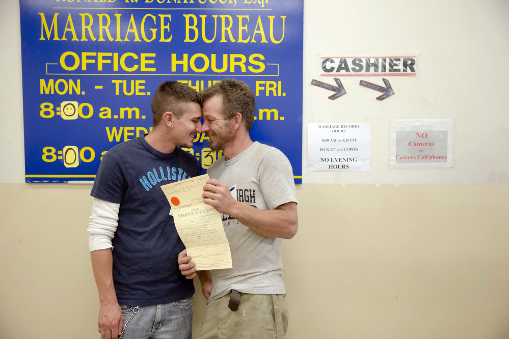 William Roletter, left, and Paul Rowe, press close to each other after they having their photo taken for their marriage certificate on Wednesday at City Hall in Philadelphia. On Tuesday, Pennsylvania became the final Northeastern state and the 19th in the U.S. to legalize same-sex marriage.