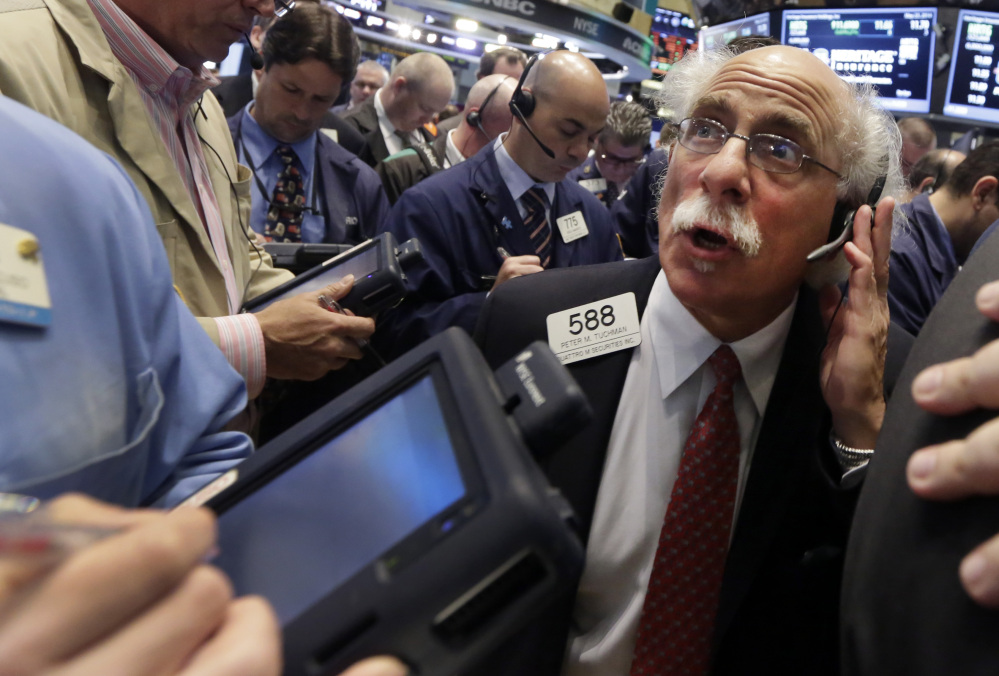 Trader Peter Tuchman, right, works on the floor of the New York Stock Exchange on Friday.