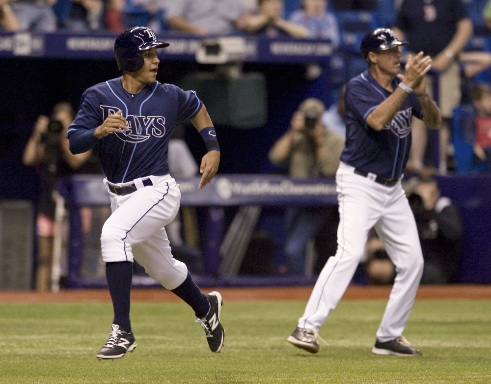 Tampa Bay pinch runner Cole Figueroa races past third-base coach Tom Foley to score the winning run in the 15th inning as the Rays beat the Red Sox, 6-5.