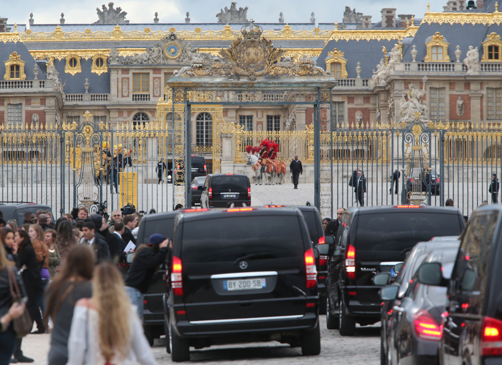 Fans gather to watch guests arriving, as they look inside one of the cars for Kim Kardashian, Kanye West and their guests, at the entrance of the Chateau de Versailles in Versailles, France, west of Paris, on Friday. The gates of the Chateau de Versailles, once the digs of Louis XIV, will be thrown open to Kim Kardashian, Kanye West and their guests for a private evening on the eve of their marriage.