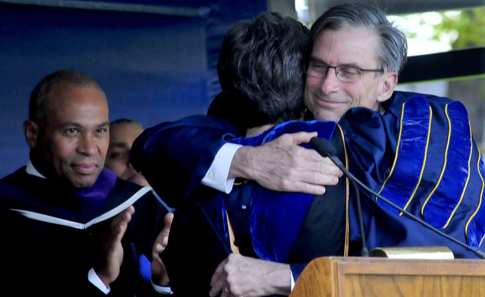 FAREWELL: Retiring Colby College President William Adams hugs Dean of Faculty Lori Kletcher after he received an honorary Doctor of Letters degree during his final commencement at the Waterville college on Sunday. Commencement speaker Massachusetts Gov. Deval Patrick is at left.