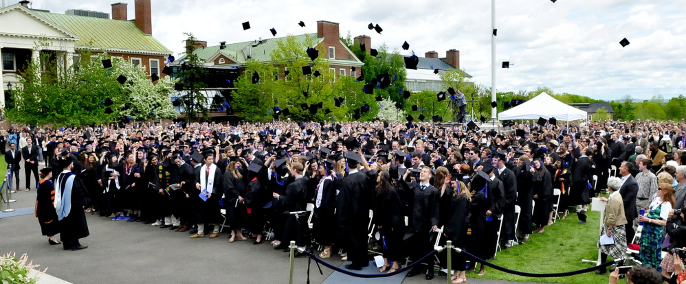UP AND AWAY: The Colby College graduating class signals the end of their commencement by tossing their mortarboard caps into the air in Waterville on Sunday.