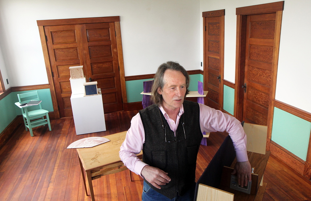 IN THE GALLERY: Dutch woodworker Erik Groenhout describes a literary cabinet on display at his gallery at the old Oddfellows Hall in Mount Vernon on Sunday. Groenhout has slowly been restoring the building since acquiring it in 2011.