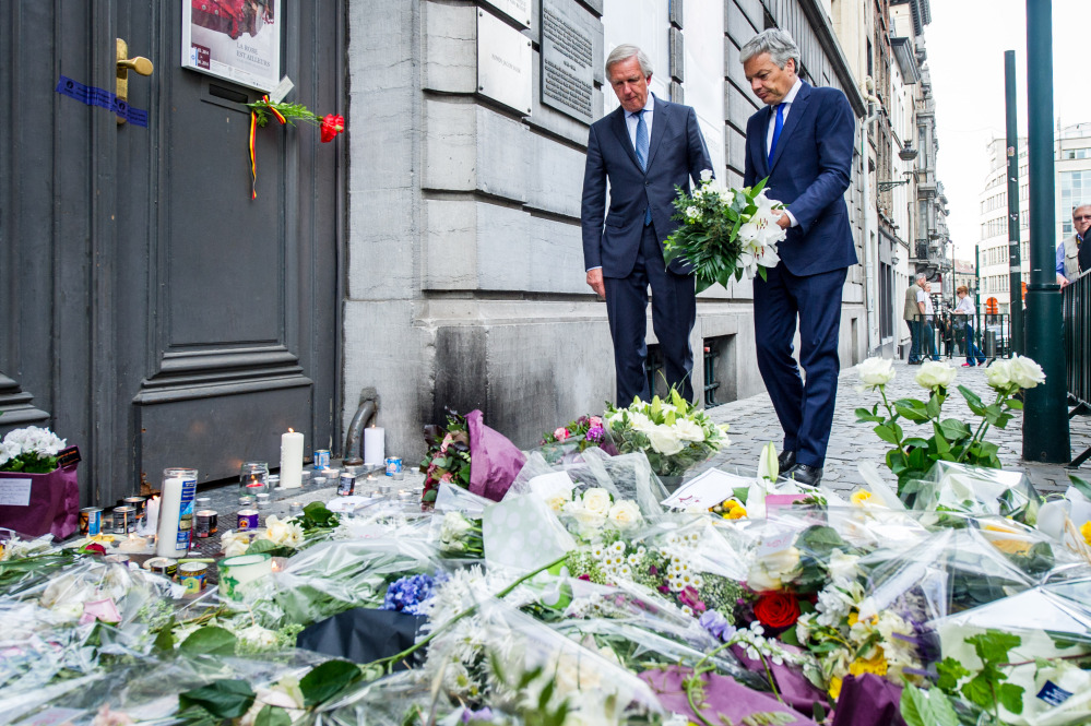 Belgium’s Foreign Minister Didier Reynders, right, lays flowers at the Jewish Museum in Brussels on Sunday. Police stepped up security at Jewish institutions, schools and synagogues after four people were killed in a spree of gunfire at the Jewish Museum in Brussels on Saturday.