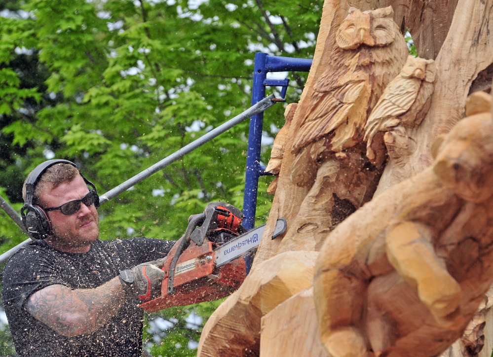 WOOD WORKER: Josh Landry carves a large maple tree Tuesday May 20 on Green Street in Winthrop.