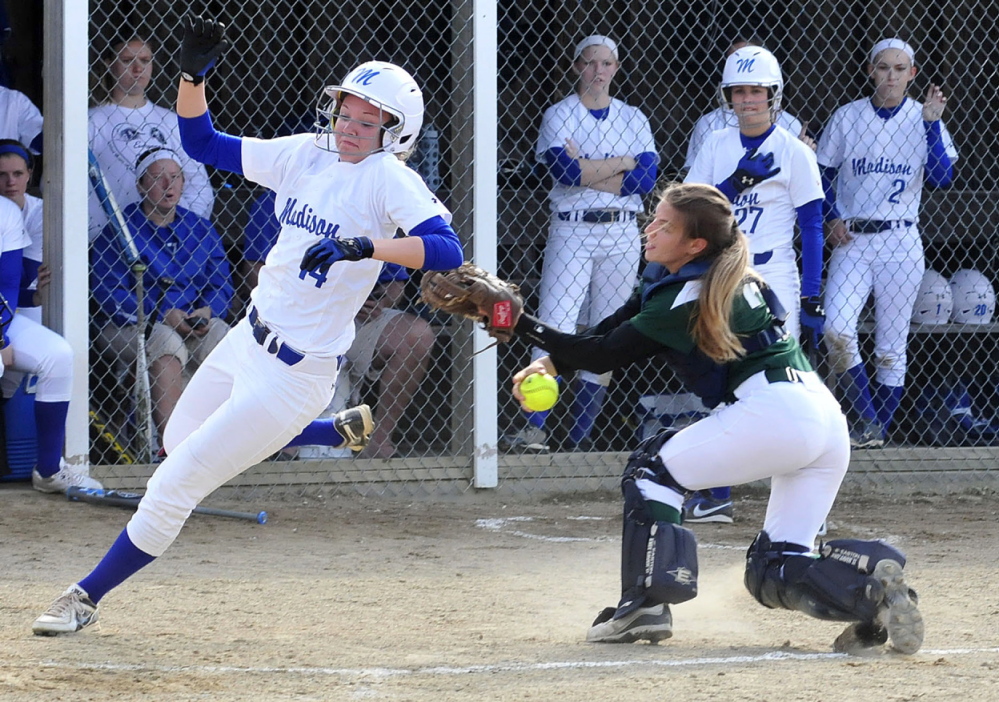 Staff photo by David Leaming SAFE: Madison’s Cristie Vicneire, left, crosses home plate as Winthrop’s catcher Cat Ouellette tries to make the tag during a game Monday in Madison. The Bulldogs won 9-0.