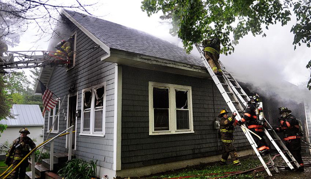 Fire response: Firefighters crawl through the second story window at a single-family Augusta home to extinguish a fire that heavily damaged the residence Wednesday. Firefighters from Augusta, Togus, Winthrop, Gardiner, Hallowell and Chelsea responded to the blaze reported just before 7 a.m.