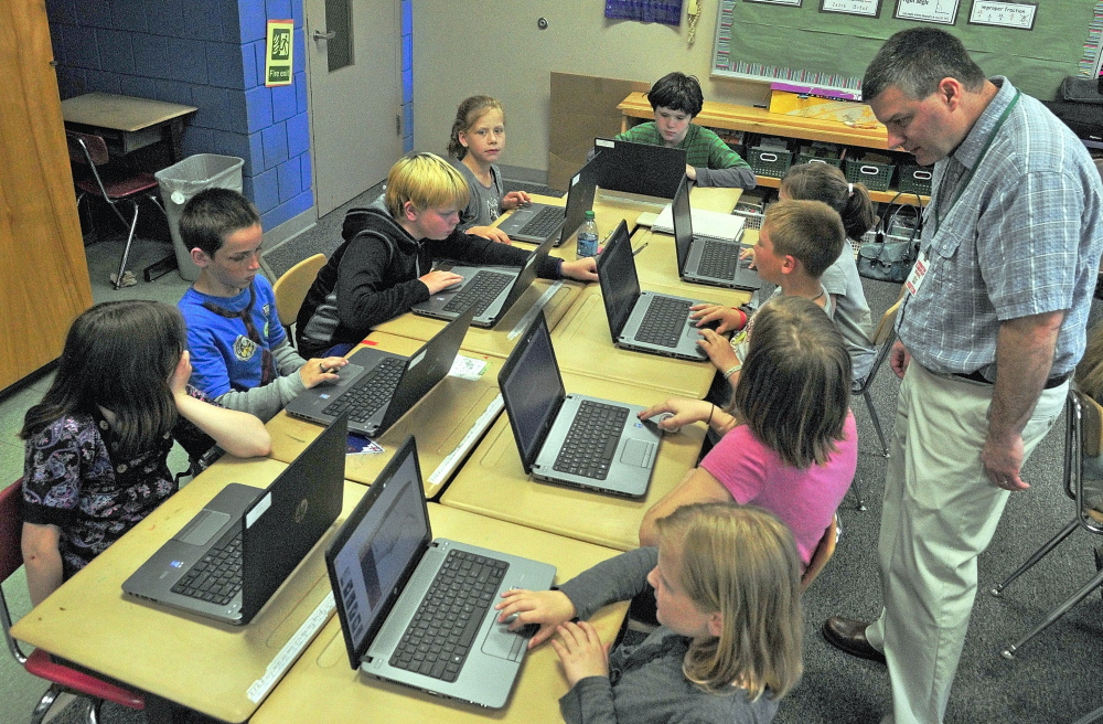 FIELD TRIP: Tony Paine, CEO of Kepware Technologies, right, chats with students during a visit on Friday, May 30 at Farrington School in Augusta. Paine’s company donated laptops to the classroom earlier in the year.