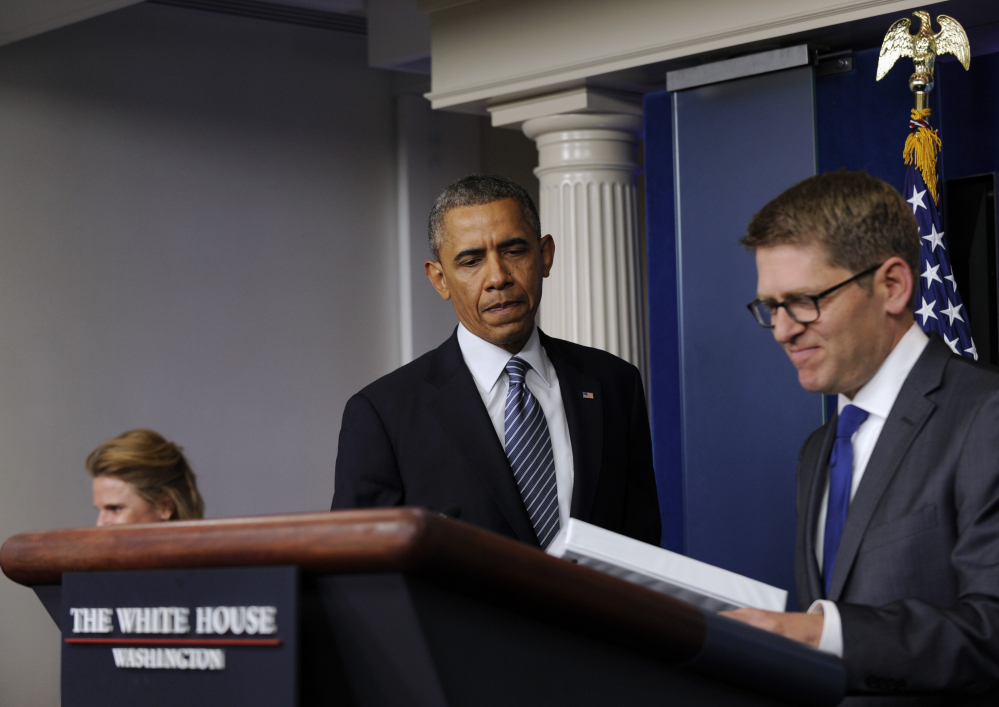White House press secretary Jay Carney closes his briefing book as President Barack Obama makes a surprise appearance to the Brady Press Briefing Room of the White House in Washington on Friday to announce that Carney will be stepping down in June.