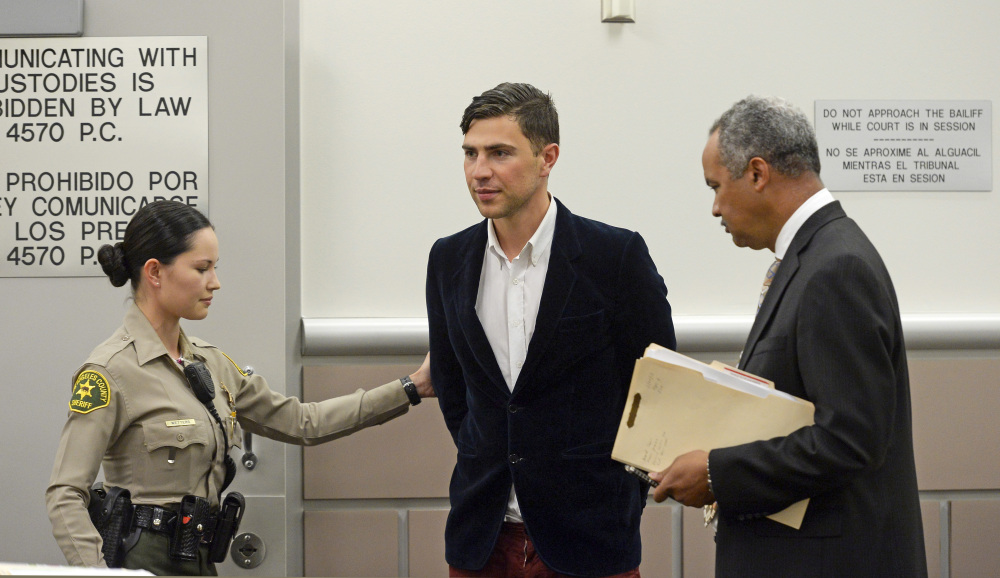 Vitalii Sediuk, from Ukraine, is led into the courtroom with his attorney Anthony Willoughby, right in Los Angeles Superior Court Friday, May 30, 2014, in Los Angeles. Sediuk faces four misdemeanor charges in connection with an alleged May 28 attack on actor Brad Pitt at a Los Angeles movie premiere.