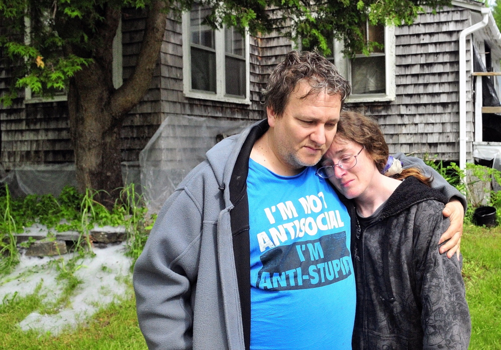 Home Lost: Patrick Lunt, left, hugs his wife, Beth Lunt, after an early morning fire on Saturday heavily damaged their home at 4 Pine Knoll Road in Winthrop. Patrick Lunt called her a hero for noticing the fire and waking him, their 19-year-old son, Storme, and another man and getting them out of the house.