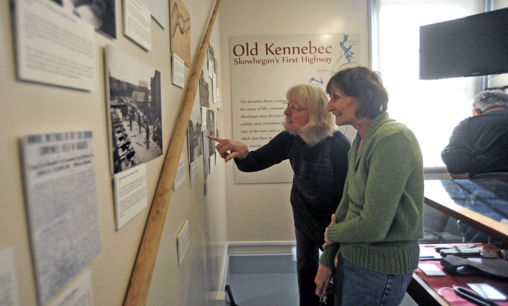 EXHIBIT: Mary Stuart points to a picture for Maureen Calder of the Old Kennebec, Skowhegan’s first highway, at an exhibit highlighting the piece of local history at The Skowhegan History House Museum & Research Center on Wednesday.
