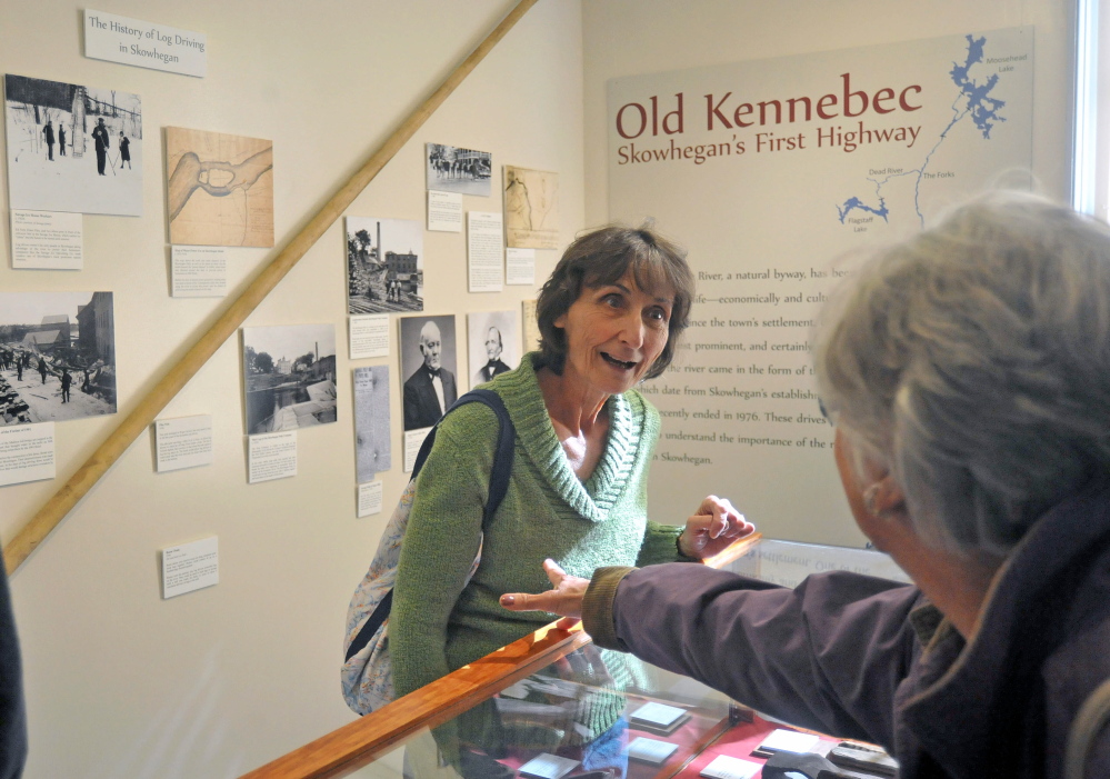 LOG DRIVE HISTORY: Maureen Calder, center, takes in the exhibit of The Skowhegan History House Museum & Research Center’s exhibit “Old Kennebec - Skowhegan’s First Highway” on Wednesday.
