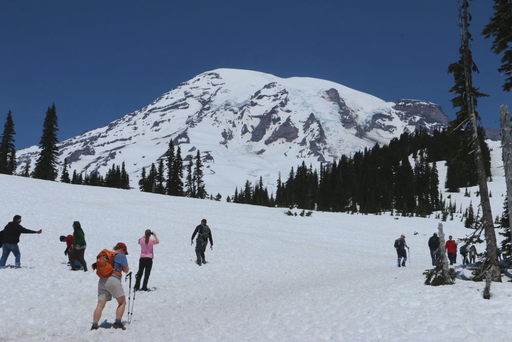 Visitors hike through the snow at the trails that start from Mount Rainier’s Paradise Visitor Center on Sunday. Officials say six climbers likely died while attempting a difficult route to the summit, in the worst alpine accident on the mountain in decades.