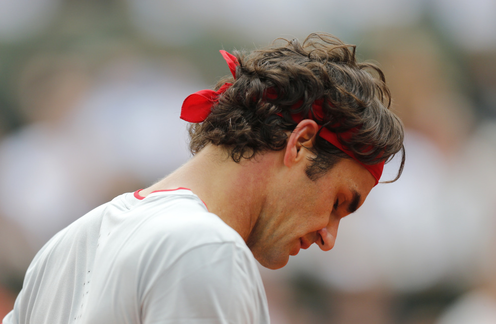 Roger Federer looks down as he plays Ernests Gulbis in the fourth round at the French Open on Sunday. Federer lost, 6-7 (5), 7-6 (3), 6-2, 4-6, 6-3.