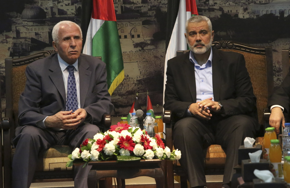 Gaza’s Hamas Prime Minister Ismail Haniyeh, right, and senior Fatah official Azzam al-Ahmad meet in Gaza for talks aimed at reaching a reconciliation agreement between the two rival Palestinian groups, Hamas and Fatah in this April 2014 file photo.