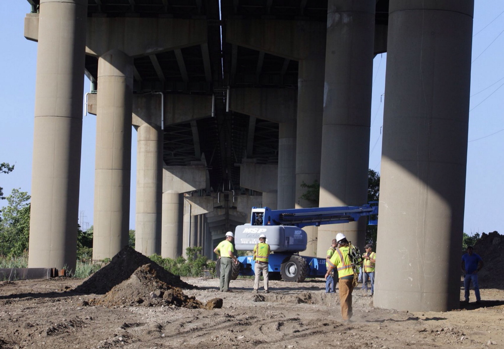DelDot crew members surround a tilted column supporting a span of the I-495 bridge over the Christina River on Monday. The 4,800-foot bridge normally carries about 90,000 vehicles a day on I-495, which diverts traffic around the city of Wilmington.