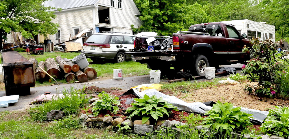 Staff photo by David Leaming CLUTTER: The front yard at the Wilton home of Duane Pollis is littered with disabled vehicles and household items beside a barn and a trailer.