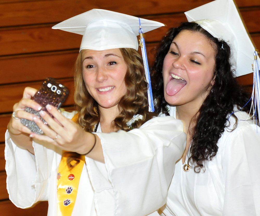 Staff photo by David Leaming SELFIE SELFIE: Lawrence High School students Aubrey Kressler, left, and Baylee Dugal pose for their own selfie portrait during commencement in Fairfield on Thursday.