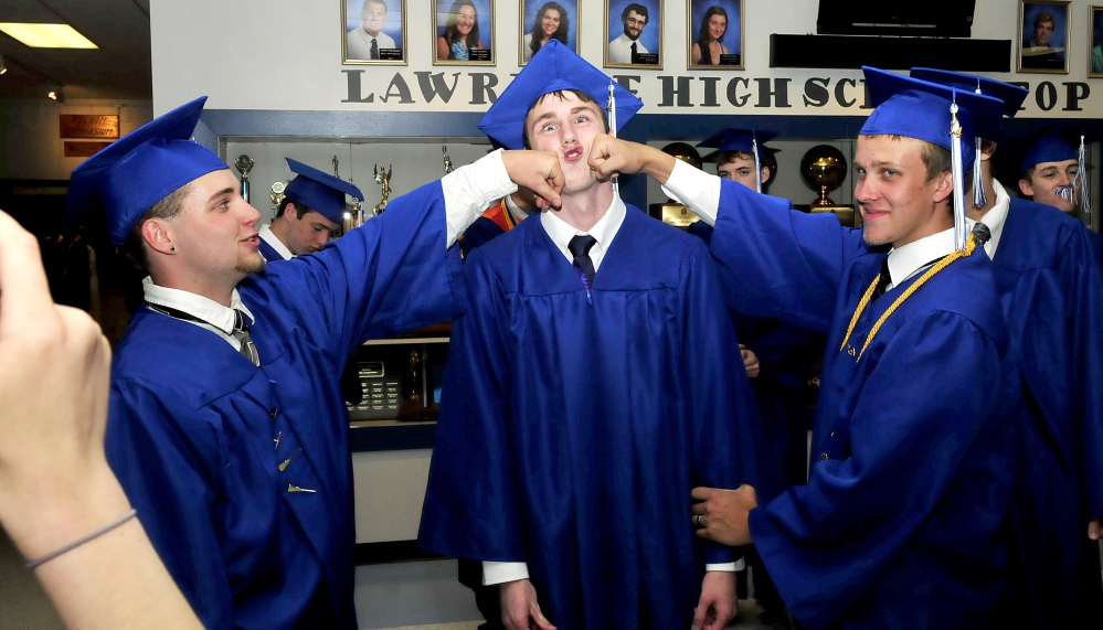 Staff photo by David Leaming LIGHT MOMENT: Lawrence High School seniors enjoy a light moment before commencement in Fairfield on Thursday. As student Dana Milburn takes photographs graduates Alex Hamlin, left, Lucas Schroeder and Ezra Shepherd provide a memorable photo opportunity.