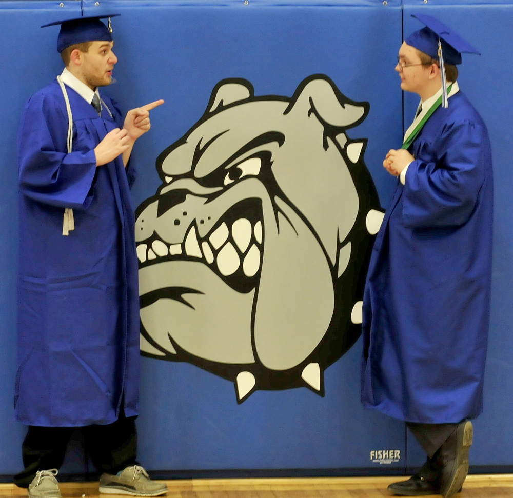 Staff photo by David Leaming DOG GONE FINISHED: Lawrence High School graduates have a last minute serious discussion beside the school mascot shortly before commencent in Fairfield on Thursday. Logan Rogers, left, and Brandon Dillon-Mulcahy share some thoughts.