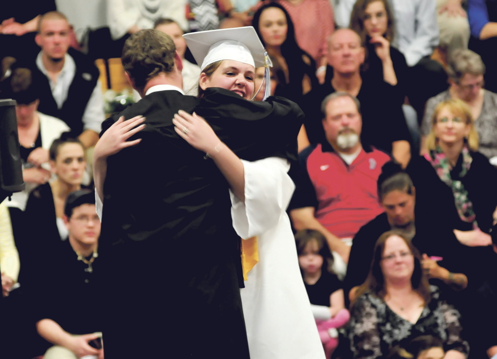 Staff photo by David Leaming THANKS: Lawrence High School Honors Speaker Josie Champagne is hugged on stage by teacher Tyler Duran during commencement in Fairfield on Thursday.