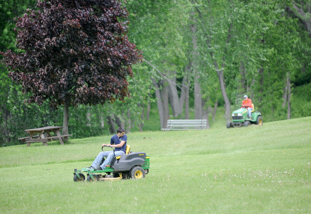 Staff photo by Michael G. Seamans Getting Ready: Winslow Parks and Recreation workers mow the grass at Fort Halifax Park in Winslow on Friday. Fort Halifax will host the Winslow Family 4th of July Celebration from July 2-4.