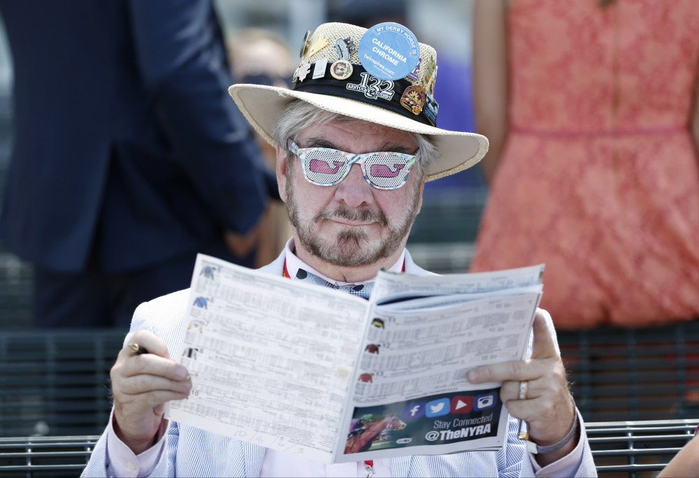 The Associated Press/Kathy Willens Charles Clarke III reads a program at Belmont Park before the Belmont Stakes horse race, Saturday, June 7, 2014, in Elmont, N.Y.