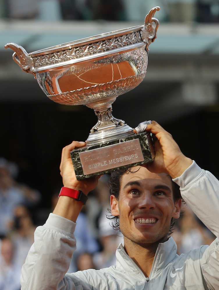 The Associated Press Rafael Nadal lifts up his cup after defeating Novak Djokovic in their final match of the French Open Sunday in Paris.