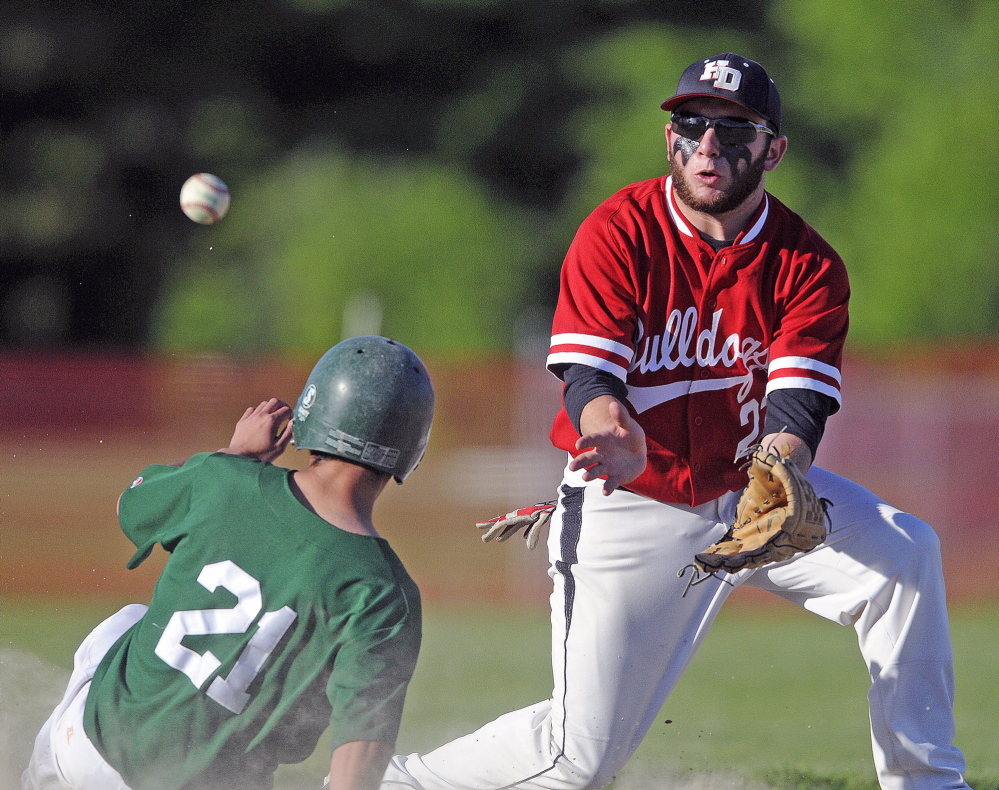 Staff photo by Andy Molloy Pitcher: Hall-Dale High School’s Alex McPherson can collect a throw to second in time to pick off Winthrop High School’s Drew Stratton Tuesday during a baseball match up in Farmingdale.