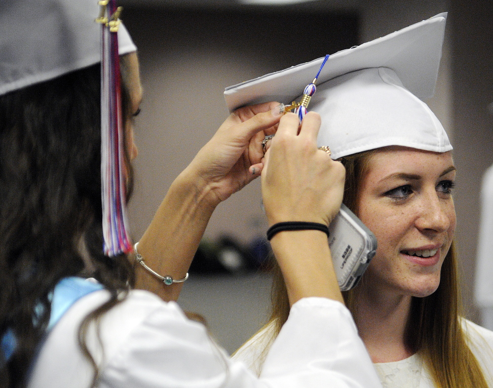 Staff photo by Andy Molloy
LAST MINUTE ADJUSTMENTS: Athena Ritchie gets her cap adjusted Monday by her classmate, Sarah Barbay, during graduation ceremonies in Augusta for Oak Hill High School.