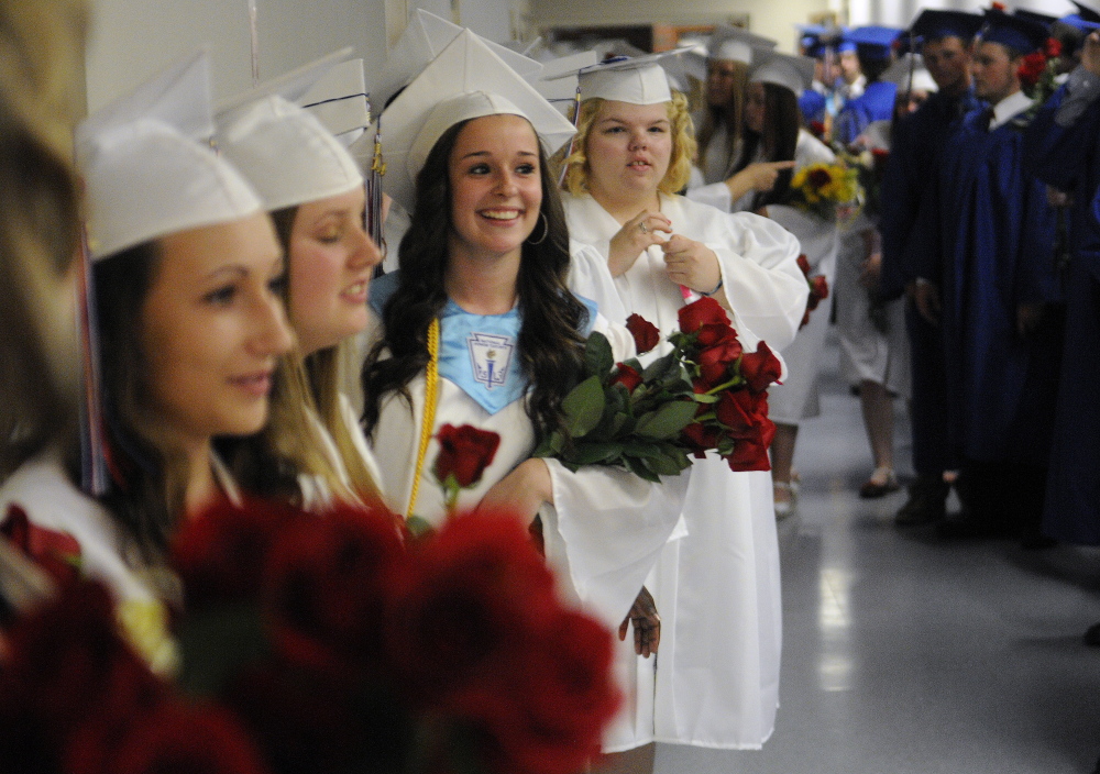 Staff photo by Andy Molloy FORM A QUEUE: Oak Hill High School seniors line up Monday to march into their graduation ceremony in Augusta.