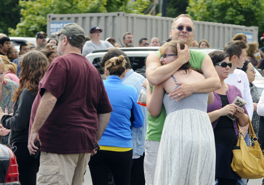 The Associated Press A family embraces as students arrived at the Fred Meyer grocery store parking lot in Wood Village, Ore., after a shooting at Reynolds High School on Tuesday.