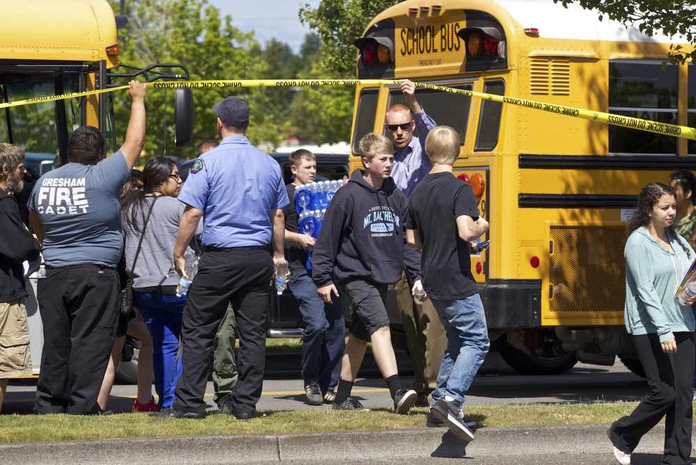 The Associated Press Students arrive by bus at the Fred Meyer grocery store parking lot in Wood Village, Ore., after a shooting at Reynolds High School on Tuesday.