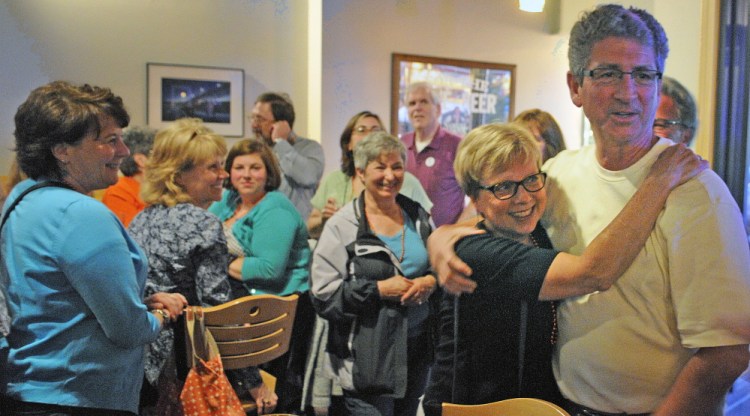 Staff Photo by Andy Molloy LIBRARY CELEBRATION: Betsy Pohl, director at Lithgow Public Library, hugs Augusta Mayor William Stokes Tuesday after they learned voters approved renovations for the Library during a gathering in Augusta.