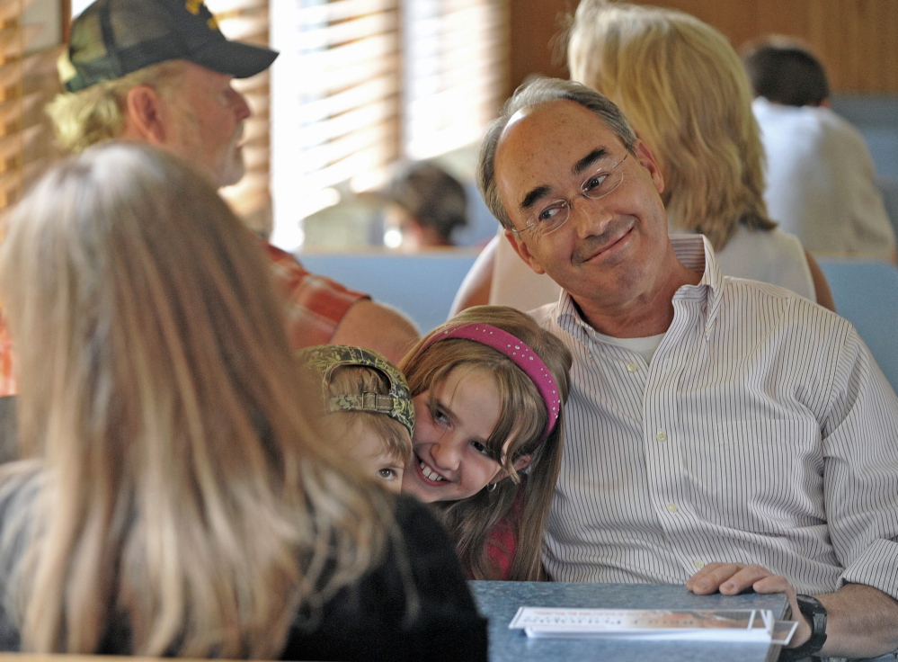 Seeking support: Bruce Poliquin, left facing, Republican candidate for Maine’s 2nd Congressional District, talks with the Katie, 9, center, Dominic, 5, left center, and mother Laura Parker, back to camera, during a visit to the Oakland House of Pizza, in Oakland, on Wednesday.