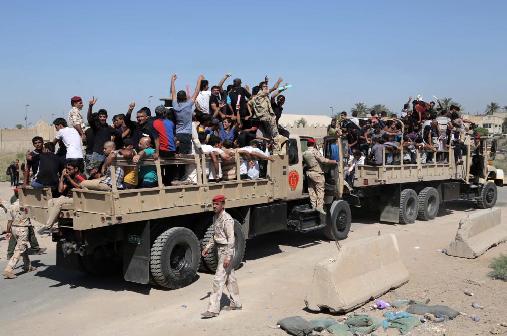 Iraqi men fill military trucks to join the Iraqi army at the main recruiting center in Baghdad, Iraq, Tuesday, after authorities issued a call to arms.