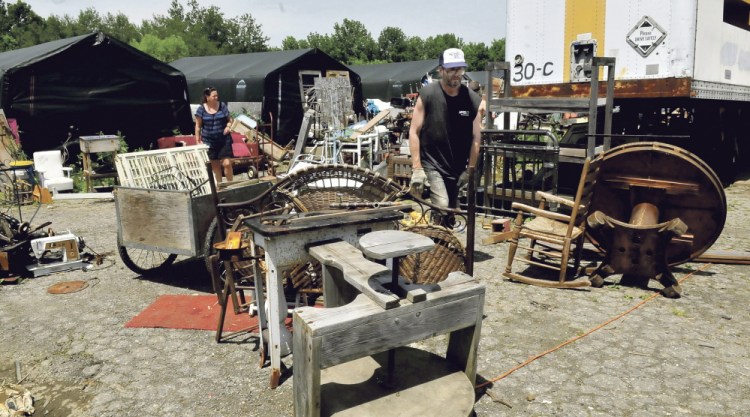 Staff photo by David Leaming
ORDER: Robert Dale, owner of Maine 201 Antiques in Fairfield, walks around piles of scattered merchandise as a woman looks at items on Tuesday.