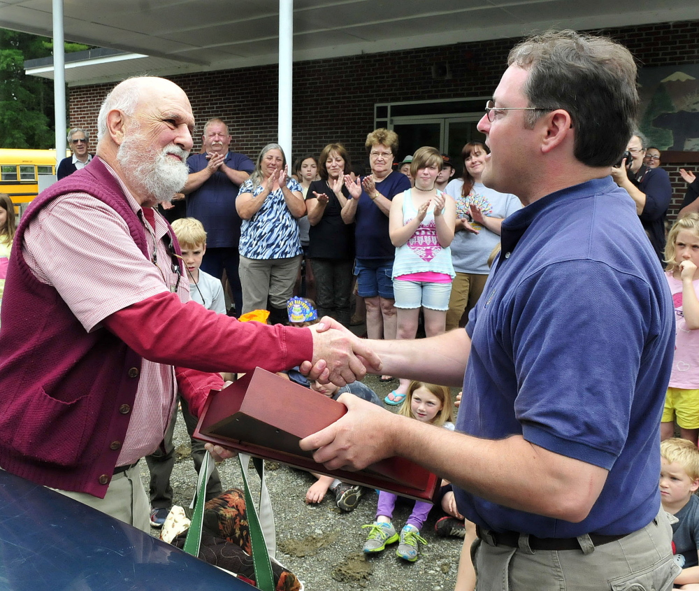 THANKS: Cornville Regional Charter School Principal William Crumley, left, is presented a folded American flag by Executive Director Justin Belanger during a ceremony marking Crumley leaving the school on Wednesday.