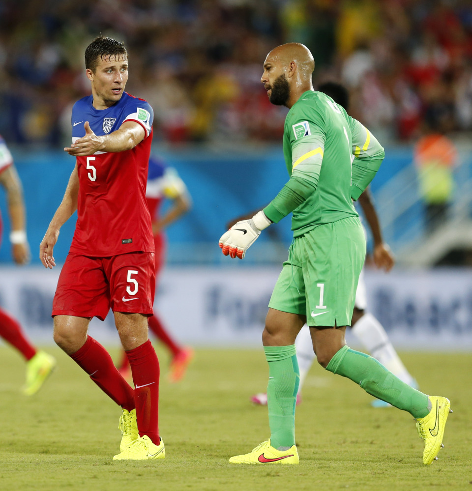 Getting it done: United States’ Matt Besler, left, talks to United States goalkeeper Tim Howard as they walk off the pitch at the half during the Group G World Cup soccer match Monday between Ghana and the United States at the Arena das Dunas in Natal, Brazil. The United States won 2-1.